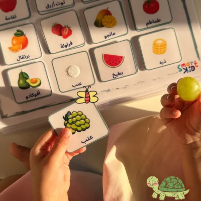 A girl matching a grapes card on the fruit and vegetables page in My Arabic Words