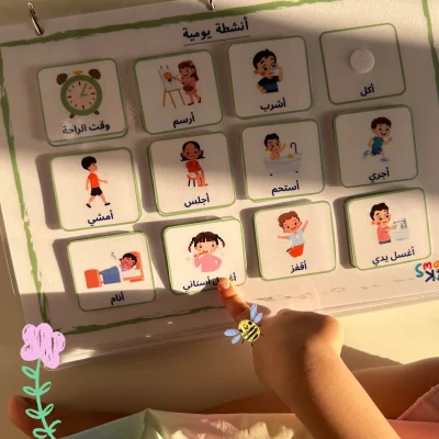 A girl pointing to the “I brush my teeth” card on the Arabic daily activities page
