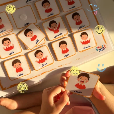 A girl holding a “sad” card from the Arabic feelings cards, alongside happy, scared and angry