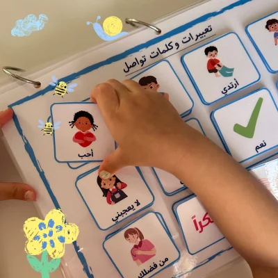 A girl holding an “I love” card in the Arabic communication activity