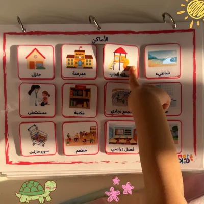 A girl pointing to a playground card on the places page in My Arabic Words