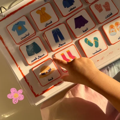 A girl matching Arabic clothing cards such as trousers, skirt, shoes and hat