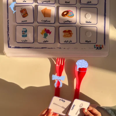 A girl matching fork and spoon cards on the Arabic snacks page