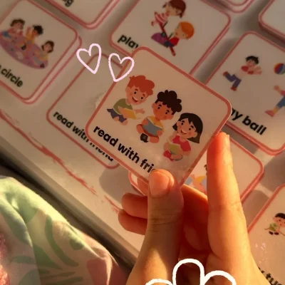 A girl holding a “read with friends” card to learn English social actions
