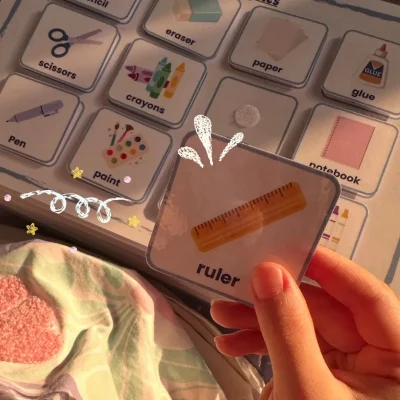 A girl holding a ruler card on the English school supplies page