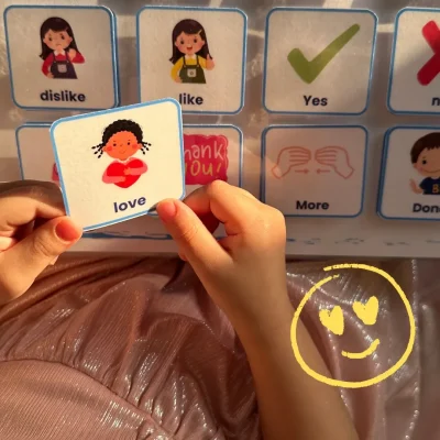 A girl holding a “love” card to learn English feeling words